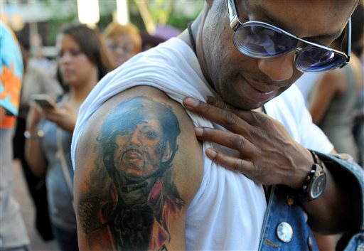 Longtime fan Luther Washington, stationed at Ft Meade, shows off his Prince tattoo while waiting for the doors to open for Prince's Baltimore concert Sunday, May 10, 2015. (Jerry Jackson/The Baltimore Sun via AP)