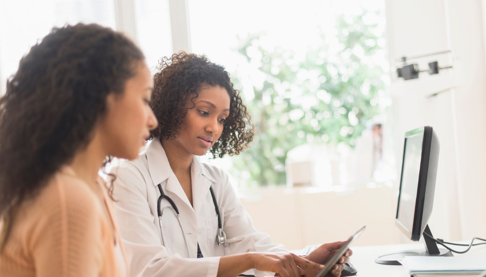 Doctor and patient using digital tablet in office