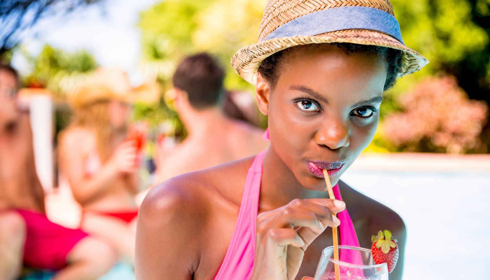 African american woman drinking cocktail simming pool