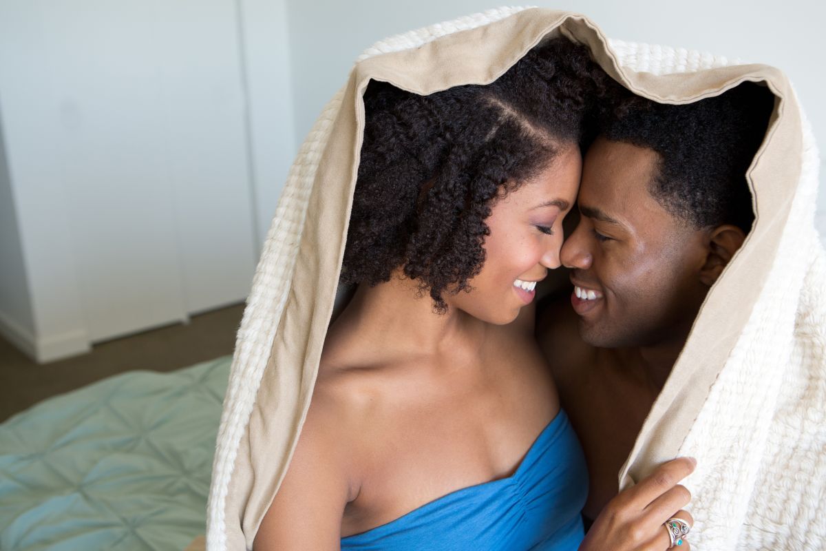 Young woman nuzzling under blanket