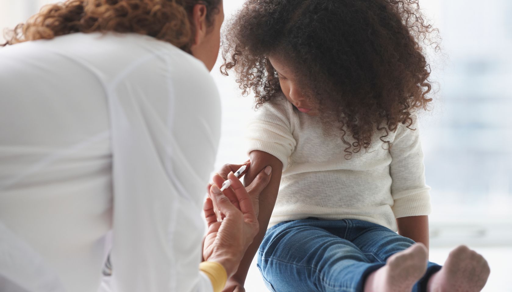 Doctor vaccinating girl in office