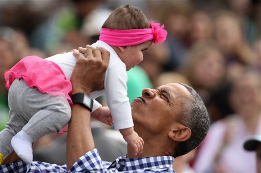 President Barack Obama holds up Stella Muñoz in the air as he visits children at the egg roll station of the White House Easter Egg Roll at the White House in Washington, Monday, March 28, 2016. Thousands of children gathered at the White House for the annual Easter Egg Roll. This year's event features  live music, sports courts, cooking stations, storytelling, and Easter egg rolling.  (AP Photo/Andrew Harnik)