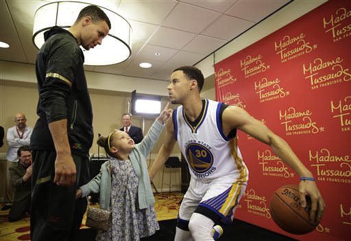 Golden State Warriors guard Stephen Curry, left, watches his daughter Riley as she examines his wax figure by Madame Tussauds after its unveiling Thursday, March 24, 2016, in Oakland, Calif. The figure of the NBA MVP will go on display at Madame Tussauds wax museum at Fisherman's Wharf in San Francisco. (AP Photo/Eric Risberg)