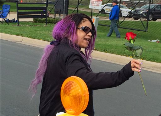 Tyka Nelson holds a rose outside Paisley Park, the home of her brother Prince in Chanhassen, Minn., on Thursday, April 21, 2016. Nelson went out to thank fans who gathered at the home to mourn the loss of the pop star who died Thursday. (AP Photo/Steve Karnowski)