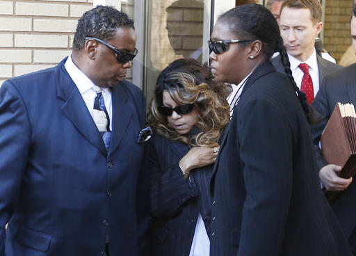 Tyka Nelson, center, the sister of Prince, is escorted by unidentified people as she leaves the Carver County Courthouse Monday, May 2, 2016, in Chaska, Minn. where a judge has confirmed the appointment of a special administrator to oversee the settlement of Prince's estate. The pop singer died on April 21 at the age of 57. (AP Photo/Jim Mone)