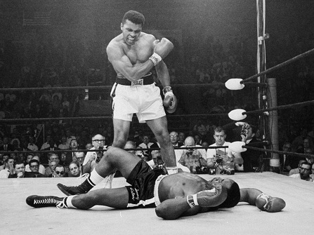 **FILE**Heavyweight champion Muhammad Ali, then known as Cassius Clay, stands over challenger Sonny Liston, shouting and gesturing shortly after dropping Liston with a short hard right to the jaw, in Lewiston, Me. in this May 25, 1965 file photo. Ali was declared the winner. The bout lasted only one minute into the first round. (AP Photo/John Rooney)
