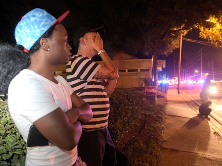 Jermaine Towns, left, and Brandon Shuford wait down the street from a multiple shooting at a nightclub in Orlando, Fla., Sunday, June 12, 2016. Towns said his brother was in the club at the time. A gunman opened fire at a nightclub in central Florida, and multiple people have been wounded, police said Sunday. (AP Photo/Phelan M. Ebenhack)