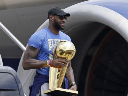 Cleveland Cavaliers' LeBron James carries The Larry O'Brien NBA Championship Trophy after arriving in Cleveland, Monday, June 20, 2016. (AP Photo/Tony Dejak)