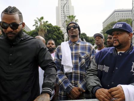Entertainers The Game, left, and Snoop Dogg, center, lead a march in support of unification outside of the graduation ceremony for the latest class of Los Angeles Police recruits in Los Angeles, Friday, July 8, 2016. The group were looking to bring a peaceful gathering of support after the killings of multiple police officers in Dallas on Thursday night. (AP Photo/Richard Vogel)