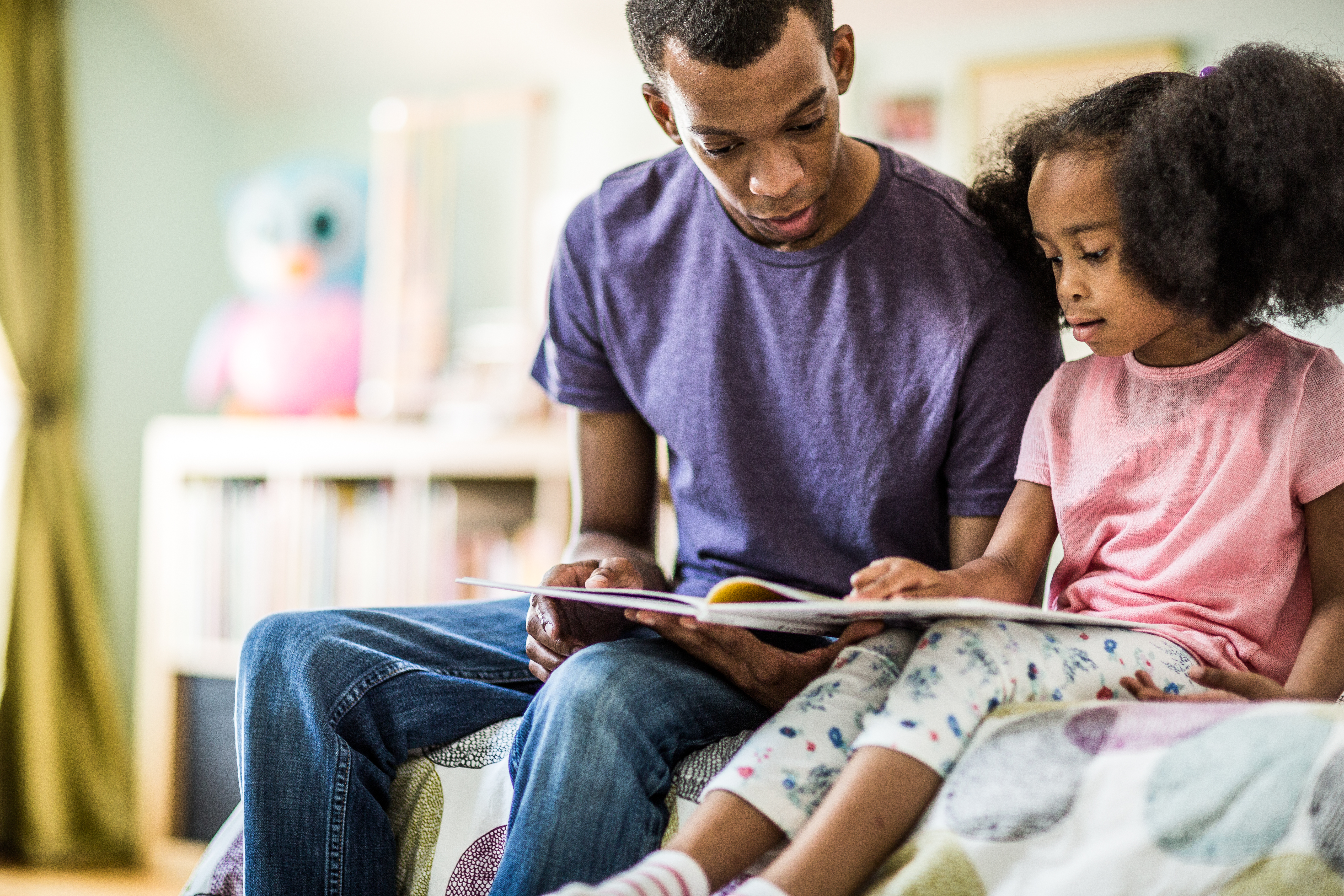 father and daughter reading at home