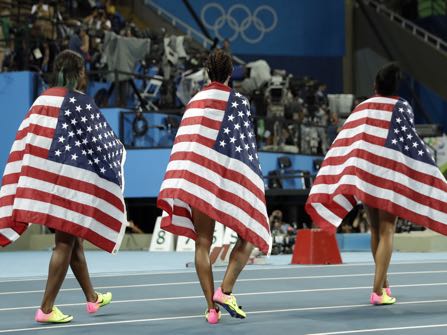 Gold medal winner Brianna Rollins, center, silver medal winner, Nia Ali, left , and bronze medal winner Kristi Castlin, all from the United States, pose with their country's flag after the 100-meter hurdles final, during the athletics competitions of the 2016 Summer Olympics at the Olympic stadium in Rio de Janeiro, Brazil, Wednesday, Aug. 17, 2016. (AP Photo/Matt Dunham)