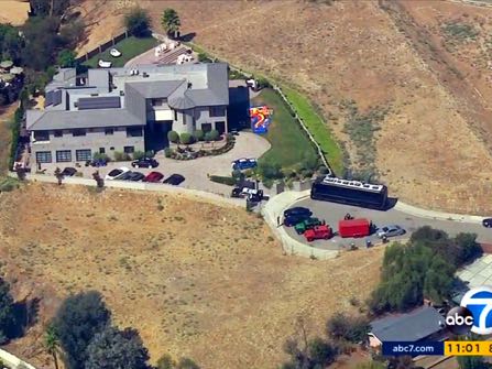 This still frame from aerial video provided by KABC-TV shows the home of entertainer Chris Brown with police vehicles outside, in the Tarzana area of Los Angeles Tuesday, Aug. 30, 32016. Authorities waited for a search warrant outside Brown's Los Angeles home Tuesday after a getting a woman's call for help, officials said. Inside, the entertainer, who has a history of legal problems, posted videos to social media declaring his innocence. (KABC-TV via AP) MANDATORY CREDIT TV OUT