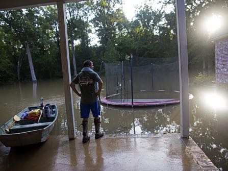 David Key looks at the back yard of his flooded home in Prairieville, La., Tuesday, Aug. 16, 2016. Key, an insurance adjuster, fled his home as the flood water was rising with his wife and three children and returned today to assess the damage. (AP Photo/Max Becherer)