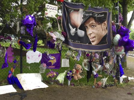 HOLD FOR STORY BY STEVE KARNOWSKI - FILE - In this May 11, 2016, file photo, items left by fans at a memorial for Prince hang from a fence outside the musician’s Paisley Park estate in Chanhassen, Minn. Work to settle the estate of the late rock superstar is moving forward, though a closed hearing is expected this week to resolve an undisclosed dispute between the likely heirs and the trust company that’s managing the estate. Prince died of an accidental painkiller overdose in April. (AP Photo/Jeff Baenen, File)