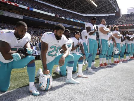 From left, Miami Dolphins' Jelani Jenkins, Arian Foster, Michael Thomas, and Kenny Stills, kneel during the singing of the national anthem before an NFL football game against the Seattle Seahawks, Sunday, Sept. 11, 2016, in Seattle. (AP Photo/Stephen Brashear)