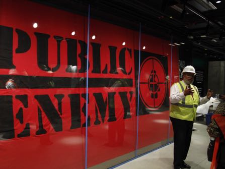 Museum Director Lonnie Bunch, second to the right, stands in-front of an art piece representing hip-hop group Public Enemy within Smithsonian’s National Museum of African American History and Culture, Monday, July 18, 2016, in Washington. Bunch lead the media tour and said that the museum will be able to hold a capacity of 15,000 people per day. The museum's grand opening will be on Sept. 24. (AP Photo/Paul Holston)
