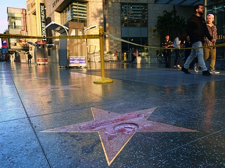 Pedestrians walk past a cordoned off area surrounding the vandalized star for Republican presidential candidate Donald Trump on the Hollywood Walk of Fame, Wednesday, Oct. 26,2016, in Los Angeles. Det. Meghan Aguilar said investigators were called to the scene before dawn Wednesday following reports that Trump's star was destroyed by blows from a hammer. (AP Photo/Richard Vogel)