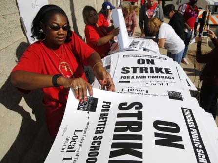 Retired Chicago school teacher Patricia Lofton counts through a stack of picket sign for Chicago Teachers Union members to pick up Monday, Oct. 10, 2016, in Chicago. Negotiators for the union and Chicago Public Schools continue to meet in an effort to reach a contract and avert a threatened teachers' strike. (AP Photo/Charles Rex Arbogast)