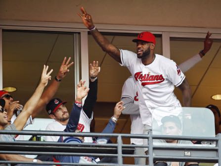 FILE - In this Oct. 15, 2016, file photo, Cleveland Cavaliers' LeBron James stands during the seventh inning in Game 2 of baseball's American League Championship Series between the Cleveland Indians and the Toronto Blue Jays in Cleveland. When LeBron James and the Cavaliers, whose historic comeback in June against Golden State in the NBA Finals ended Cleveland’s title drought dating to 1964, receive their championship rings and a banner is raised in Quicken Loans Arena before their season opener, the emotional ceremony will merely be the warm-up act. Next door, at Progressive Field, the Indians will host the Chicago Cubs in Game 1 of the World Series.  (AP Photo/Gene J. Puskar, File)