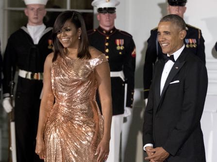 President Barack Obama and first lady Michelle Obama wait at North Portico of the White House to greet Italian Prime Minister Matteo Renzi and his wife Agnese Landini, for a State Dinner, Tuesday, Oct. 18, 2016. The first lady is wearing a floor length, rose gold chainmail gown designed by Atelier Versace. (AP Photo/Manuel Balce Ceneta)