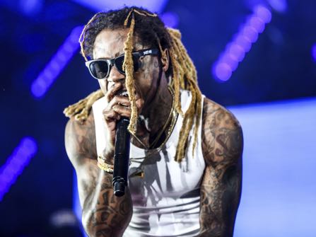 FILE - In this June 25, 2016 file photo, Lil Wayne performs at the 2016 BET Experience in Los Angeles. The rapper got some backlash when he told Fox Sports 1’s “Undisputed” that there was “no such thing as racism” because his concert audiences had a a lot of white fans. He also said he had never dealt with racism. Lil Wayne said Tuesday, Oct. 11, that one of the reasons he feels that way is because a white police officer saved his life when he was 12-years old after a self-inflicted gunshot wound to the chest.(Photo by Rich Fury/Invision/AP, File)
