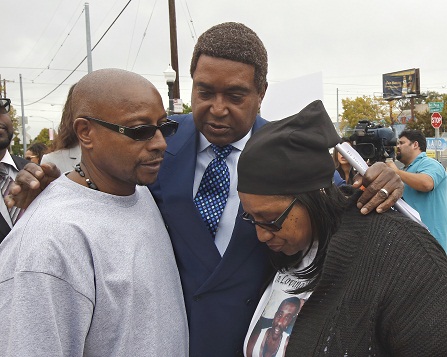 Attorney John Burris, center, comforts Robert and Deborah Mann, family members of Joseph Mann, who was killed by Sacramento Police in July, after a news conference Monday, Oct. 3, 2016, in Sacramento, Calif.  The Mann family is demanding that the officers involved in shooting of Joseph Mann, 50, be charged with murder and that the U.S. Department of Justice open a civil rights investigation of the Sacramento Police Department. (AP Photo/Rich Pedroncelli)