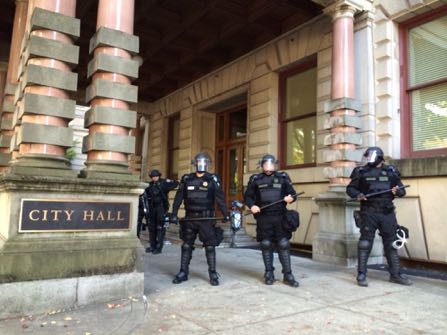 Portland police stand guard outside of City Hall in Portland, Ore., Wednesday, Oct. 12, 2016. The Portland City Council approved a new police contract in a conference room that was blocked off from the general public because of protests that led to arrests. (Brad Schmidt/The Oregonian via AP)