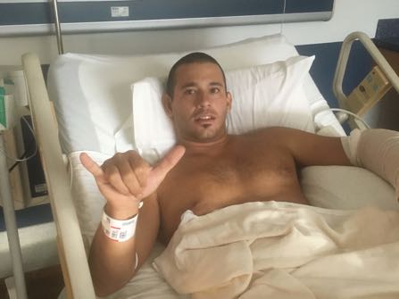 In this photo provided by Kari Feinstein, surfer Federico Jaime poses for a photo from his hospital bed in Wailuku, Hawaii on Friday, Oct. 21, 2016. Jaime was surfing Friday at a beach about two blocks from his Paia home when he felt a shark chomp down on his left arm, he recalled Monday from his room at Maui Memorial Medical Center. Jamie says he's grateful to be recovering in a Maui hospital after a shark bit him — even though the attack forced him and his wife, Kari Feinstein,, to postpone their honeymoon. (Kari Feinstein via AP)