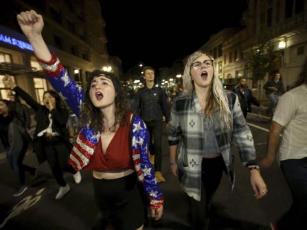 Madeline Lopes, left, and Cassidy Irwin, both of Oakland, march with other peaceful protesters onTelegraph Avenue in downtown Oakland, Calif., on Tuesday, Nov. 8, 2016. Donald Trump defeated Hillary Clinton in the presidential race. (Jane Tyska/Bay Area News Group)