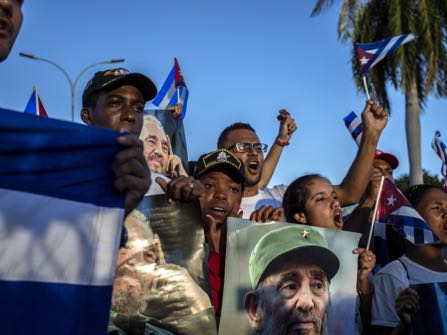 People hold pictures of late Fidel Castro near Santa Ifigenia cemetery in Santiago, Cuba, Sunday, Dec. 4, 2016. Thousands of people lined the short route from the Plaza Antonio Maceo or Plaza of the Revolution to the cemetery where the ashes were be buried in a private ceremony near the grave of Cuba's independence hero Jose Marti. (AP Photo/Desmond Boylan)