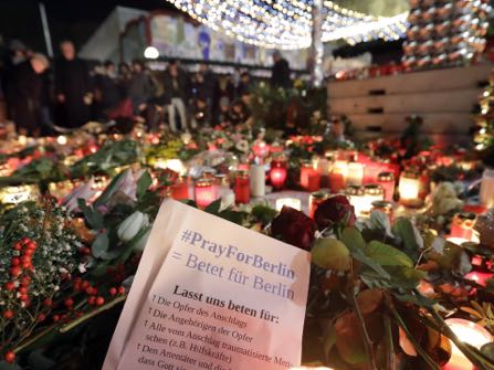 People stay in front of candles close to a Christmas market beside the memorial church in Berlin, Germany, Wednesday, Dec. 21, 2016, two days after a truck ran into a crowded Christmas market and killed several people. (AP Photo/Michael Sohn)