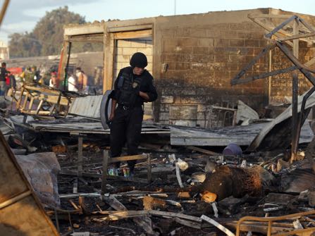 A Mexico State policeman looks through the scorched ground of the open-air San Pablito fireworks market, in Tultepec, outskirts of Mexico City, Mexico, Tuesday, Dec. 20, 2016. An explosion ripped through Mexico’s best-known fireworks market on the northern outskirts of the capital Tuesday, injuring scores and killing dozens, according to Mexican Federal Police. (AP Photo/Eduardo Verdugo)
