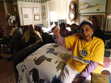 In this May 27, 2015 photo, Golden State Warriors fan Helen Brooks, better known as Sweetie, reacts as she watches an NBA playoff basketball game between the Warriors and the Houston Rockets on television with family and friends in Hayward, Calif. Brooks, a 107-year-old Northern California woman who gained fame very late in life as an avid and gregarious fan of the Warriors, died Thursday Dec. 22, 2016. (Josie Lepe/Bay Area News Group via AP)