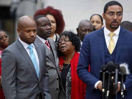 FILE- Judy Scott, center, Walter Scott's mother, is comforted by her son Rodney Scott, as the family attorneys, Chris Stewart, left, and Justin Bamberg, right, hold a press conference after the mistrial was declared for the Michael Slager trial Monday Dec. 5, 2016, in Charleston, S.C. Former patrolman, Slager, is charged with murder in the shooting death of Walter Scott last year. (AP Photo/Mic Smith, File)