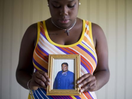 FILE-In this Friday, June 19, 2015 file photo, Najee Washington holds a photo of her grandmother Ethel Lance, one of the nine people killed in Wednesday's shooting at Emanuel AME Church, by Dylan Roof, as she poses for a portrait outside her home, in Charleston, S.C. "She cared for everyone.During Dylan Roof's sentencing for friends and family members walked up to the witness stand and testified about the nine black church members gunned down during a Bible study. The testimony came during the sentencing phase of Dylann Roof's death penalty trial. (AP Photo/David Goldman, File)