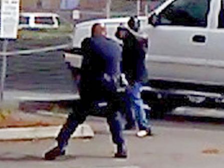 FILE - In this Tuesday, Sept. 27, 2016 file frame from bystander video provided by the El Cajon Police Department, Alfred Olongo, right, is seen pointing what was later determined to be a bulky electronic cigarette device at El Cajon, Calif., police officer Richard Gonsalves during a confrontation at an El Cajon strip mall. Moments later Olongo was shot and killed. San Diego County District Attorney Bonnie Damais announced Tuesday, Jan. 10, 2017 that no criminal charges will be filed against Gonsalves. (El Cajon Police Department/San Diego County District Attorney's Office via AP, File)