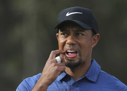 In this Thursday, Feb. 2, 2017, photo, Tiger Woods reacts on hole 11th during the 1st round of the Dubai Desert Classic golf tournament in Dubai, United Arab Emirates. Woods has withdrawn from the Dubai Desert Classic with an apparent back injury after shooting an opening-round 5-over 77. (AP Photo/Kamran Jebreili)