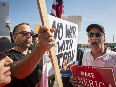 A President Donald Trump supporter, right, clashes with Trump protesters at a "Trump Not Welcome" protest near the corner of Interbay Boulevard and South Dale Mabry Highway in Tampa, Fla., on Monday, Feb. 6, 2017. A Trump visit to MacDill Air Force Base prompted the protest. (Loren Elliott/Tampa Bay Times via AP)