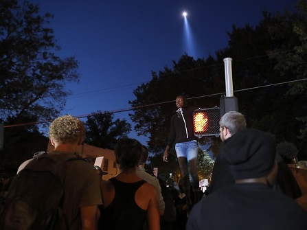 Protester standing on top of a traffic signal