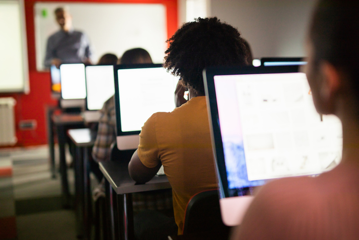 Back view of a black student attending a class at computer lab.