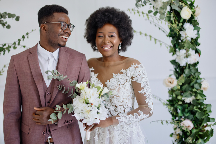 Portrait of newlyweds, groom and bride embracing near altar