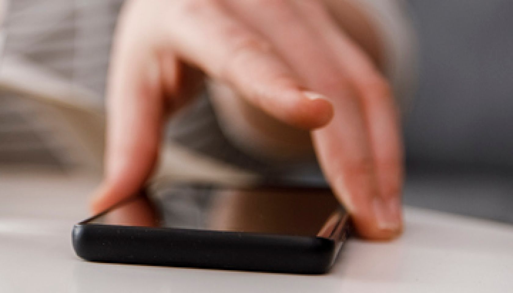 Reaching for her smart phone to check text messages