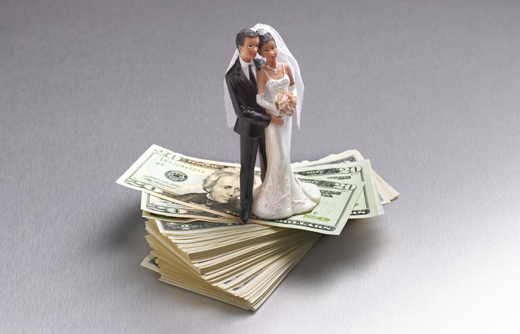 COUPLE STANDING ON US DOLLARS