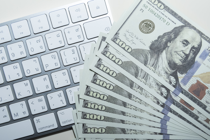 Many cash 100 Dollar on keyboard computer.