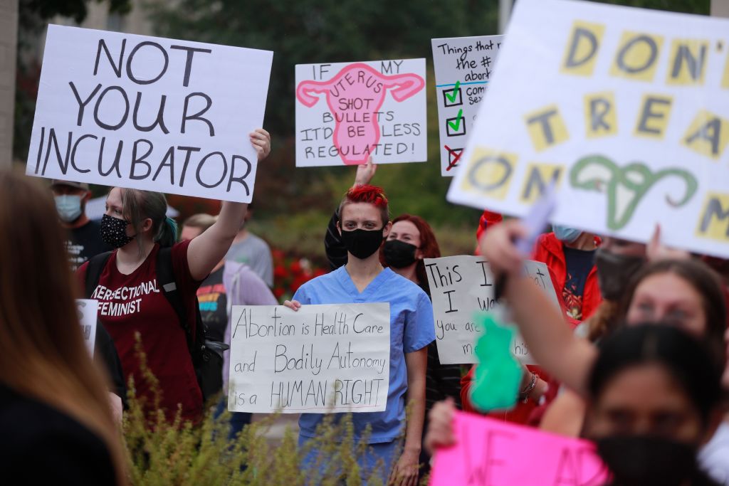 Demonstrators gather with placards expressing their opinion...