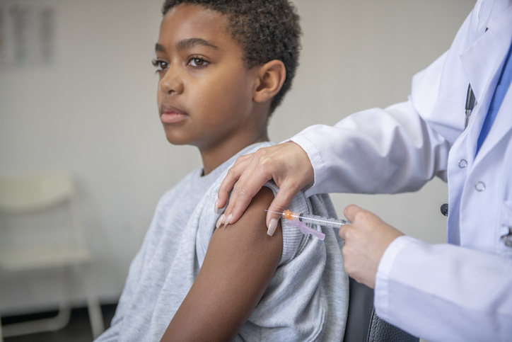 Doctor Administering a Needle to a Young Boy