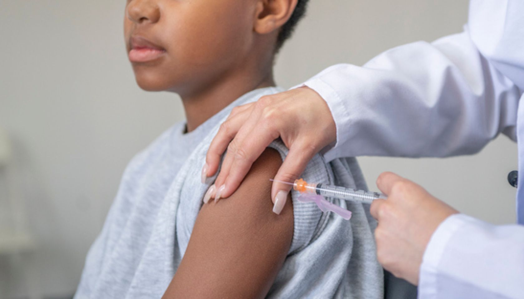 Doctor Administering a Needle to a Young Boy