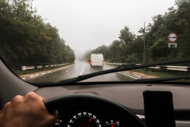 Inside view of a car on road traffic and a sign of prohibited overtaking and radar