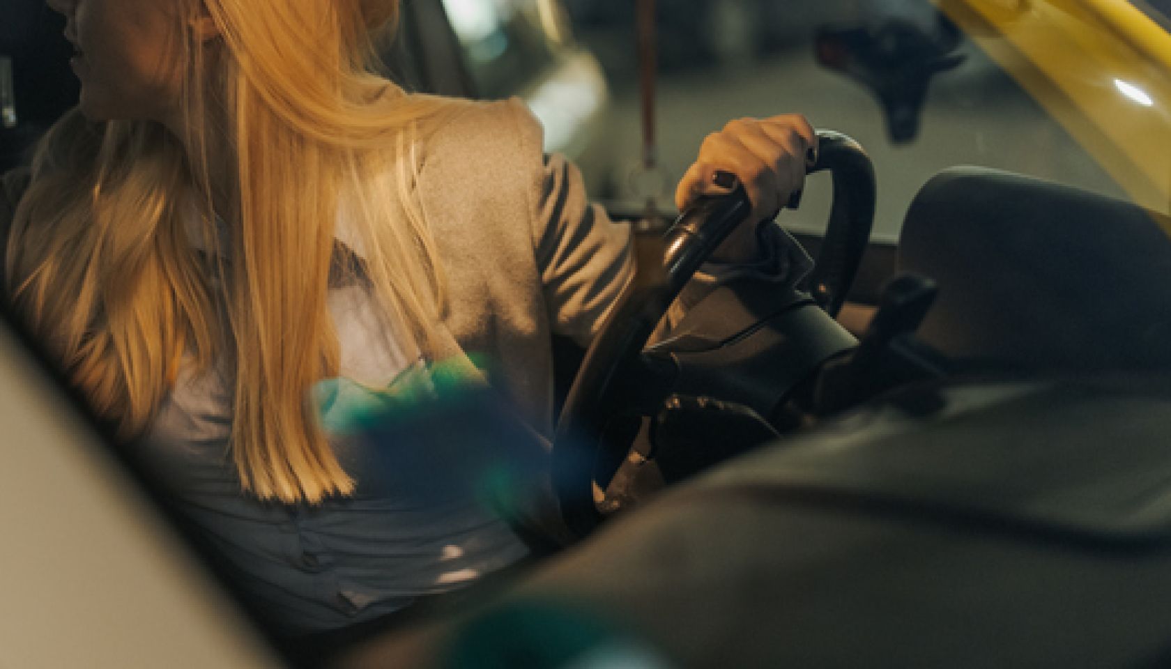 Beautiful young woman driving car at night