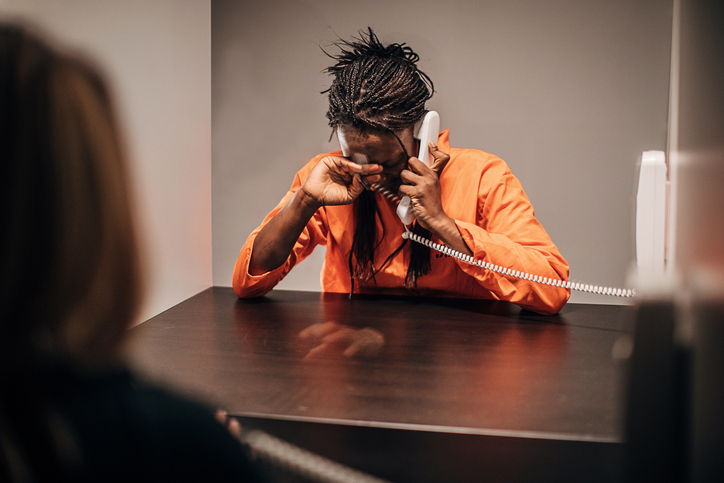 Lesbian couple sitting in prison visiting room